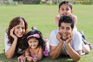 family laying on the grass