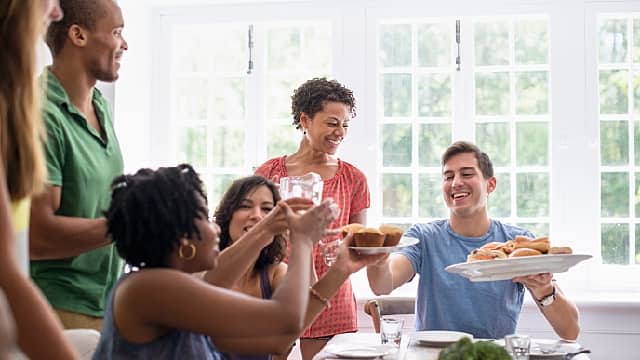 Grupo de amigos sonriendo y disfrutando de una comida