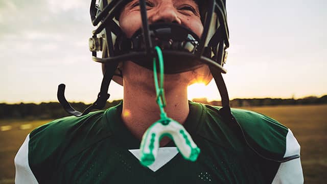 Football player in full gear standing on a field
