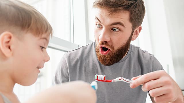 hijo y padre cepillandose los dientes