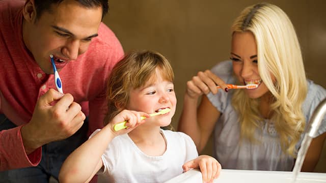 Familia felíz cepillandose los dientes