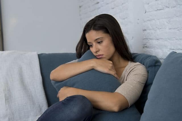 Mujer sentada preocupada y pensativa