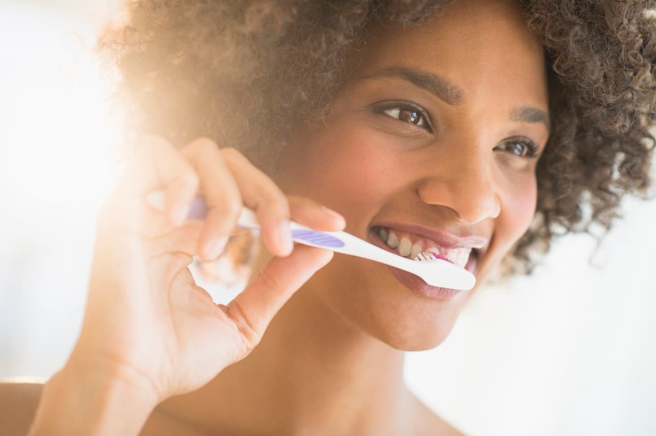 Foto de una mujer cepillándose los dientes