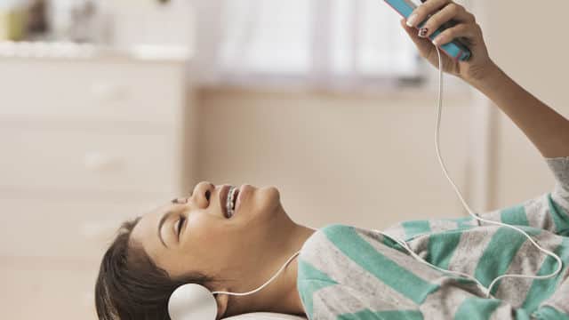 Mujer escuchando música y sonriendo