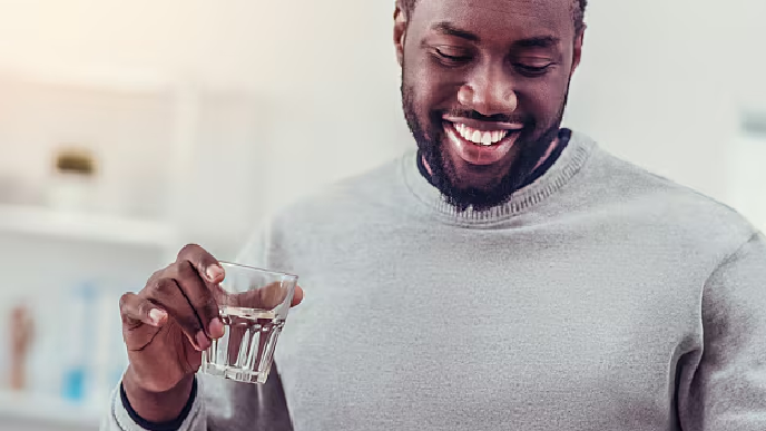 Hombre tomando la medicacion con agua