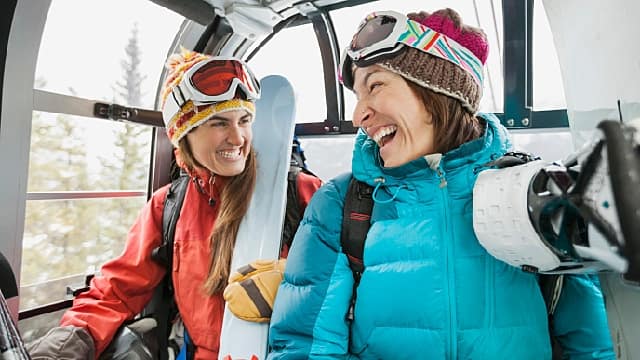 two people smiling on ski lift